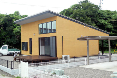 他の地域にある小さなモダンスタイルのおしゃれな家の外観 (漆喰サイディング、黄色い外壁) の写真