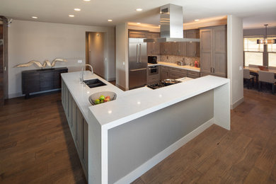 Large minimalist medium tone wood floor and brown floor open concept kitchen photo in San Luis Obispo with an island, recessed-panel cabinets, medium tone wood cabinets, quartzite countertops, a double-bowl sink, beige backsplash, glass tile backsplash and stainless steel appliances