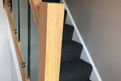 Modern carpeted wood railing staircase in West Midlands.