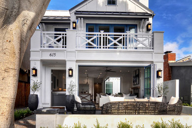 Example of a mid-sized beach style white two-story vinyl exterior home design in Los Angeles with a metal roof