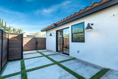 Example of a small transitional one-story stucco exterior home design in Los Angeles with a tile roof and a brown roof