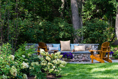 Inspiration for a mid-sized partial sun backyard stone formal garden in Boston with a fire pit for summer.