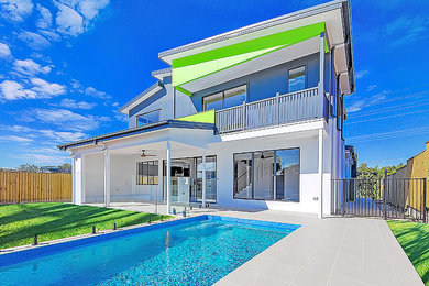This is an example of a mid-sized modern rectangular natural pool in Brisbane with tile.