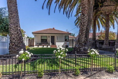 Example of a small transitional beige one-story stucco house exterior design in San Francisco with a red roof
