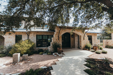 Huge southwest beige two-story stone house exterior photo in Austin with a shed roof and a metal roof