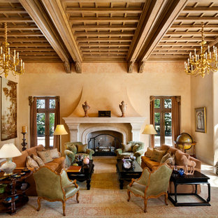 Diseño de salón para visitas cerrado, mediterráneo, grande, sin televisor, con paredes beige, chimenea tradicional, marco de chimenea de piedra y moqueta