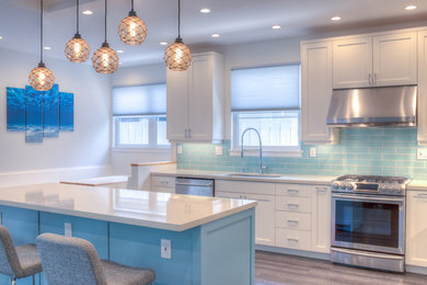 Open concept kitchen - large contemporary l-shaped dark wood floor and brown floor open concept kitchen idea in Hawaii with an undermount sink, shaker cabinets, white cabinets, quartzite countertops, blue backsplash, porcelain backsplash, stainless steel appliances, an island and white countertops