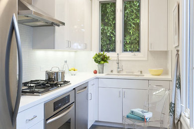 This is an example of a contemporary l-shaped separate kitchen in Los Angeles with stainless steel appliances, an undermount sink, flat-panel cabinets, white cabinets, white splashback and mosaic tile splashback.