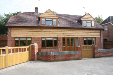 Modelo de fachada de casa roja y marrón tradicional extra grande de dos plantas con revestimiento de madera, tejado a dos aguas, tejado de teja de barro y panel y listón