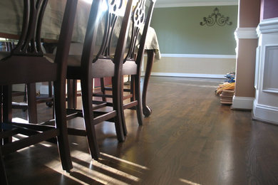 This is an example of a traditional dining room in Other with green walls, dark hardwood floors and no fireplace.
