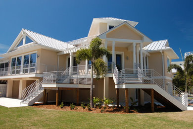 Example of a large minimalist beige three-story exterior home design in Miami