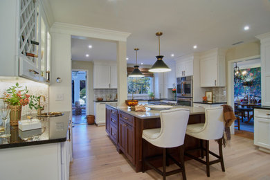 Eat-in kitchen - large transitional u-shaped light wood floor and multicolored floor eat-in kitchen idea in Baltimore with an undermount sink, recessed-panel cabinets, solid surface countertops, multicolored backsplash, porcelain backsplash, an island and gray countertops