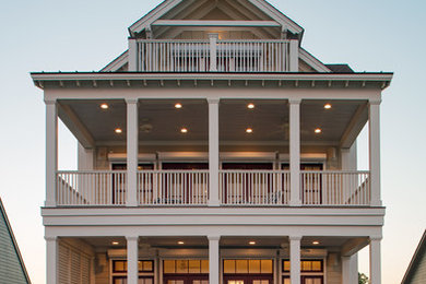 Photo of a mid-sized beach style three-storey beige house exterior in Charleston with a gable roof, concrete fiberboard siding and a shingle roof.
