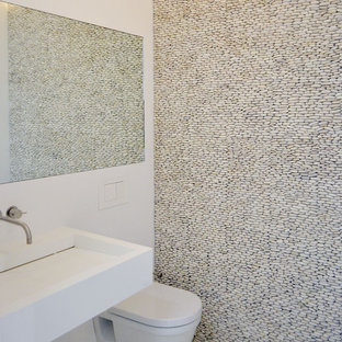 Ispirazione per un bagno di servizio moderno con WC sospeso e piastrelle di ciottoli