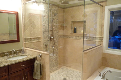 Traditional bathroom in Philadelphia with a drop-in tub and travertine.