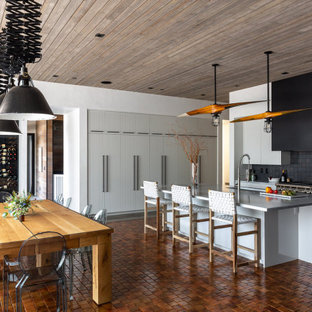 Ispirazione per una grande sala da pranzo aperta verso la cucina stile rurale con pareti bianche, pavimento in terracotta, pavimento arancione e soffitto in legno
