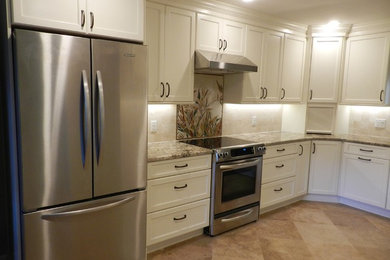 Example of a mid-sized classic u-shaped travertine floor eat-in kitchen design in Jacksonville with an undermount sink, shaker cabinets, white cabinets, granite countertops, beige backsplash, stone tile backsplash, stainless steel appliances and no island