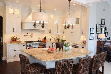 Photo of a mid-sized contemporary l-shaped eat-in kitchen in Jacksonville with a farmhouse sink, raised-panel cabinets, white cabinets, white splashback, stainless steel appliances, dark hardwood floors and with island.