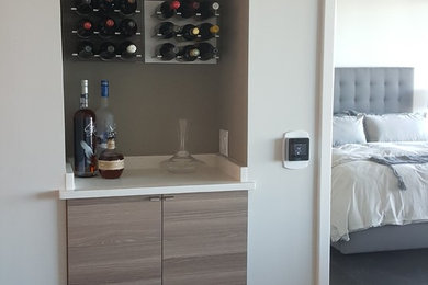 Inspiration for a small contemporary dark wood floor home bar remodel in Atlanta with flat-panel cabinets, medium tone wood cabinets and quartz countertops