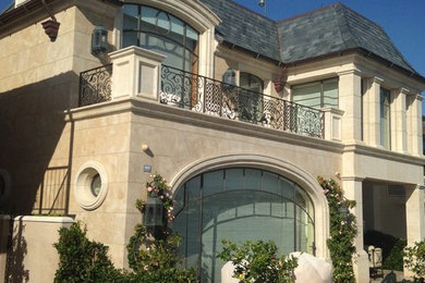 Large elegant beige two-story stone exterior home photo in Orange County