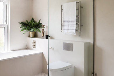 Small modern grey and white family bathroom in London with flat-panel cabinets, light wood cabinets, a built-in bath, a walk-in shower, a wall mounted toilet, grey walls, porcelain flooring, a vessel sink, engineered stone worktops, white floors, an open shower, white worktops, double sinks and a built in vanity unit.