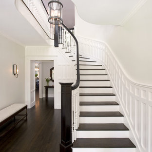 ニューヨークの大きい木のトラディショナルスタイルのおしゃれなサーキュラー階段 (木材の手すり、フローリングの蹴込み板) の写真