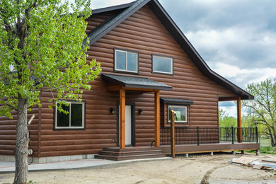 Imagen de fachada de casa marrón rústica con revestimiento de metal