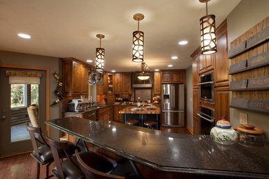 Large farmhouse u-shaped medium tone wood floor eat-in kitchen photo in Orange County with an undermount sink, raised-panel cabinets, medium tone wood cabinets, granite countertops, stainless steel appliances and an island