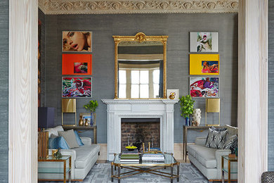 Inspiration for a large eclectic mezzanine living room in London with grey walls, light hardwood flooring, a standard fireplace, beige floors and a stone fireplace surround.