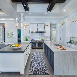 Large beach style kitchen pantry pictures - Kitchen pantry - large beach style gray floor and medium tone wood floor kitchen pantry idea in Miami with an undermount sink, recessed-panel cabinets, white cabinets, metallic backsplash, mosaic tile backsplash, stainless steel appliances, two islands, gray countertops and granite countertops