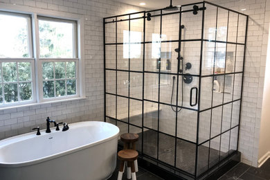 Inspiration for a mid-sized master bathroom in New York with furniture-like cabinets, distressed cabinets, a freestanding tub, a corner shower, a one-piece toilet, white tile, white walls, ceramic floors, an integrated sink, quartzite benchtops, black floor and white benchtops.
