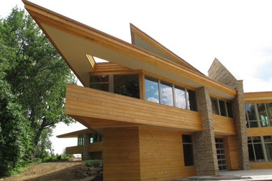 Aménagement d'une très grande façade de maison marron craftsman en bois à un étage.