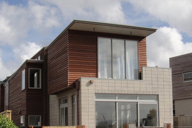 Photo of a contemporary two-storey exterior in Wellington with wood siding.