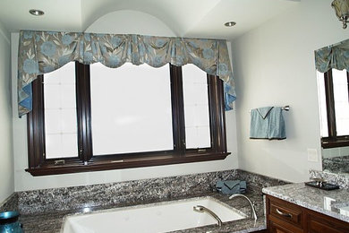 Walk-in shower - large master walk-in shower idea in Cleveland with dark wood cabinets, blue walls and granite countertops