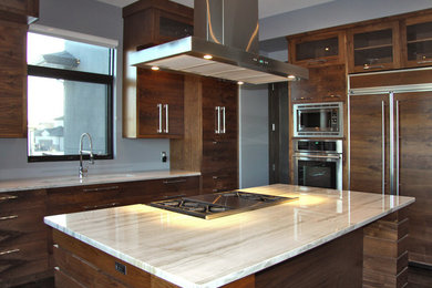 Inspiration for a large contemporary u-shaped dark wood floor open concept kitchen remodel in Other with flat-panel cabinets, medium tone wood cabinets, marble countertops, paneled appliances, two islands, a drop-in sink, white backsplash and stone slab backsplash