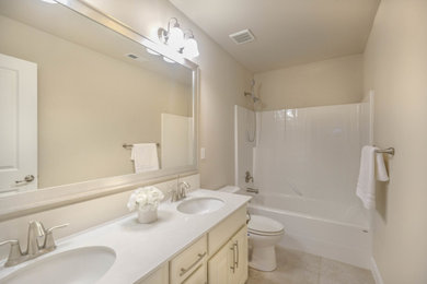 Example of a trendy double-sink bathroom design in Seattle with white cabinets