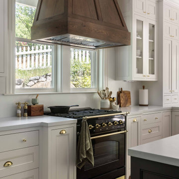 Range beneath custom wood hood with garden window