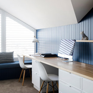 Photo of a transitional home office in Sydney with blue walls, carpet, a built-in desk and grey floor.
