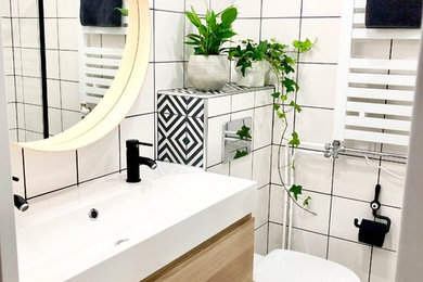 Cette image montre une petite salle de bain design en bois brun pour enfant avec WC suspendus, un carrelage blanc, un mur blanc, carreaux de ciment au sol, une grande vasque, un plan de toilette en bois, un sol noir et un plan de toilette blanc.