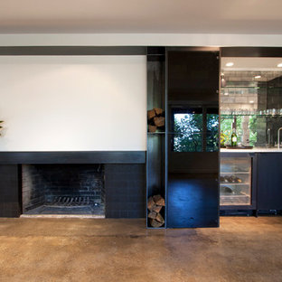 This is an example of a contemporary single-wall wet bar in Portland with concrete flooring, flat-panel cabinets, black cabinets, marble worktops and mirror splashback.