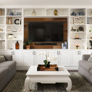 This is an example of a country open concept family room in New York with a built-in media wall, grey walls, dark hardwood floors and brown floor.