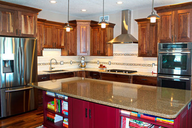 Example of a mid-sized transitional l-shaped medium tone wood floor kitchen pantry design in Other with an undermount sink, raised-panel cabinets, dark wood cabinets, quartz countertops, beige backsplash, stone tile backsplash, stainless steel appliances and an island