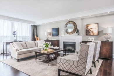 Inspiration for a mid-sized timeless formal and open concept dark wood floor and brown floor living room remodel in Toronto with beige walls, a standard fireplace, a wood fireplace surround and a concealed tv
