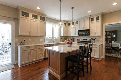 Example of a mid-sized transitional l-shaped medium tone wood floor and brown floor eat-in kitchen design in Cleveland with a double-bowl sink, flat-panel cabinets, white cabinets, quartz countertops, white backsplash, quartz backsplash, stainless steel appliances, an island and white countertops