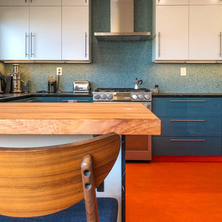 Mittelgroße Moderne Küche in U-Form mit Vorratsschrank, flächenbündigen Schrankfronten, weißen Schränken, Küchenrückwand in Blau, Küchengeräten aus Edelstahl, Linoleum, Halbinsel, orangem Boden, Einbauwaschbecken, Granit-Arbeitsplatte, Rückwand aus Mosaikfliesen und schwarzer Arbeitsplatte in Los Angeles