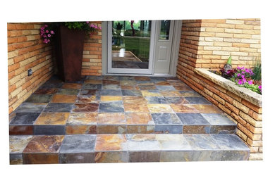 This is an example of a small tile front porch design in Chicago.