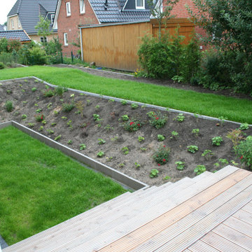 Kubisches Architektenhaus mit geometrischem Garten mit Stauden, Rosen und Obst