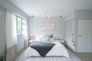 Scandinavian bedroom with grey walls, light hardwood floors and beige floor.