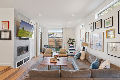 Trendy open concept light wood floor and brown floor family room photo in Los Angeles with white walls, a plaster fireplace, a ribbon fireplace and a wall-mounted tv