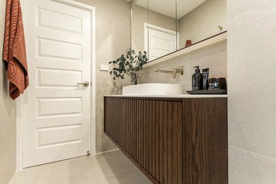 Photo of a mid-sized modern master bathroom in Sydney with dark wood cabinets, an alcove shower, a one-piece toilet, gray tile, grey walls, a drop-in sink, grey floor, a hinged shower door, white benchtops, a niche, a single vanity and a floating vanity.